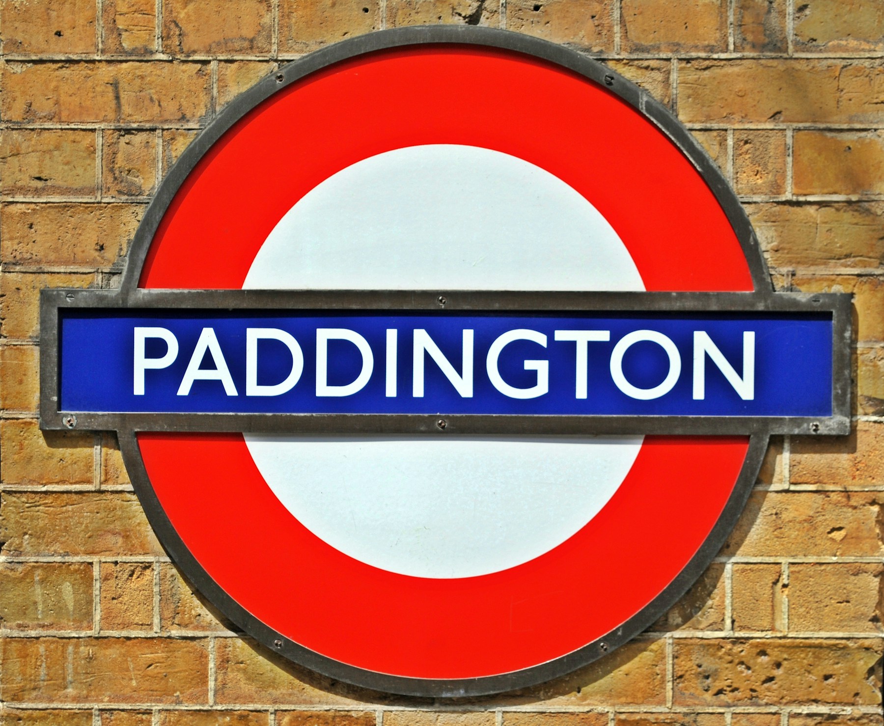 Paddington London Underground station sign on a brick wall