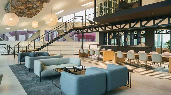 A large contemporary office lounge with meeting and collaboration areas.